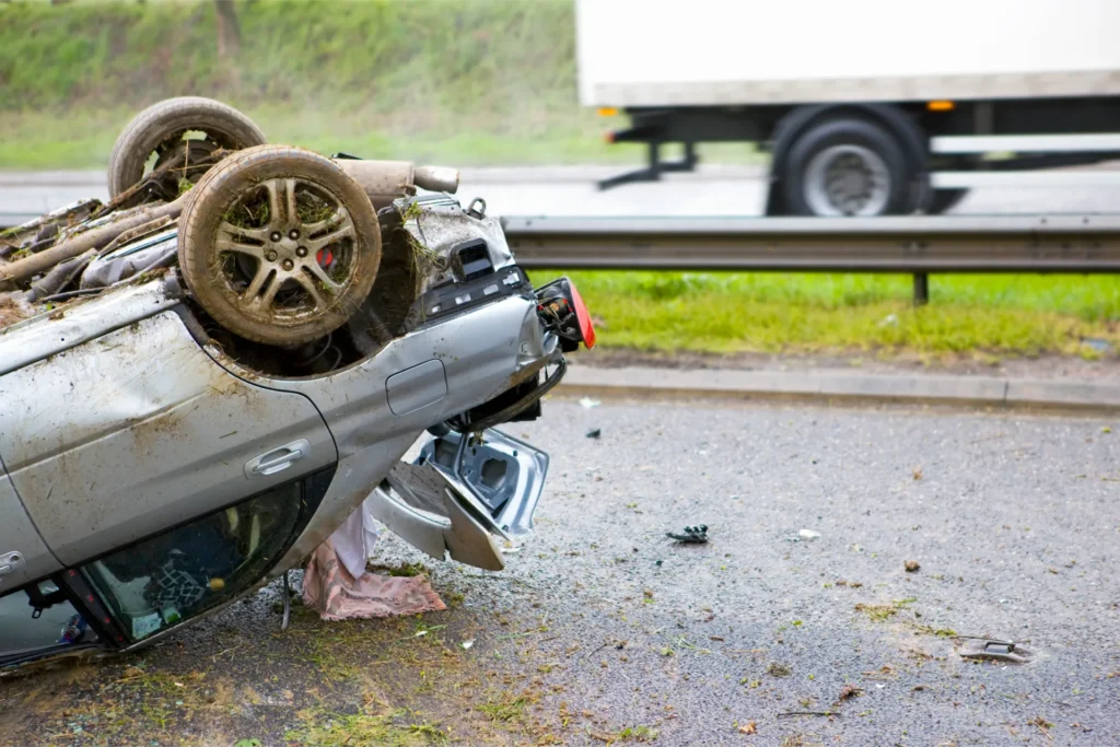 Wrecked car front with exposed steering wheel, debris, and damaged dashboard after collision roadside