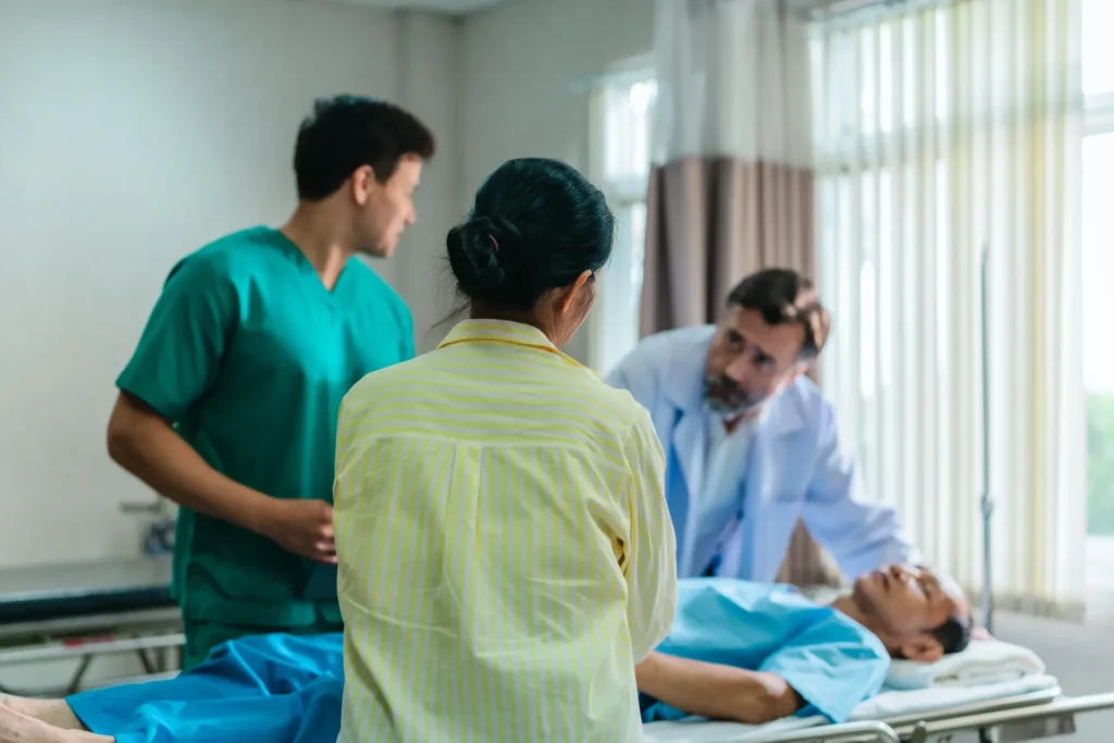 Hospital ward team provides patient care during a family visit in a bright clinic room